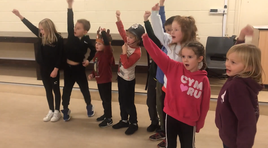 Children rehearsing and creating dance moves for the football world cup chant.