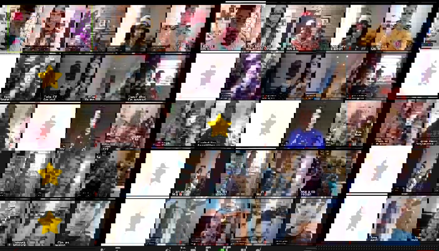 3.	Screenshot of a Zoom call with many participants. The participants are all children apart from 5 older people. All the participants apart from 4 have their camera on.